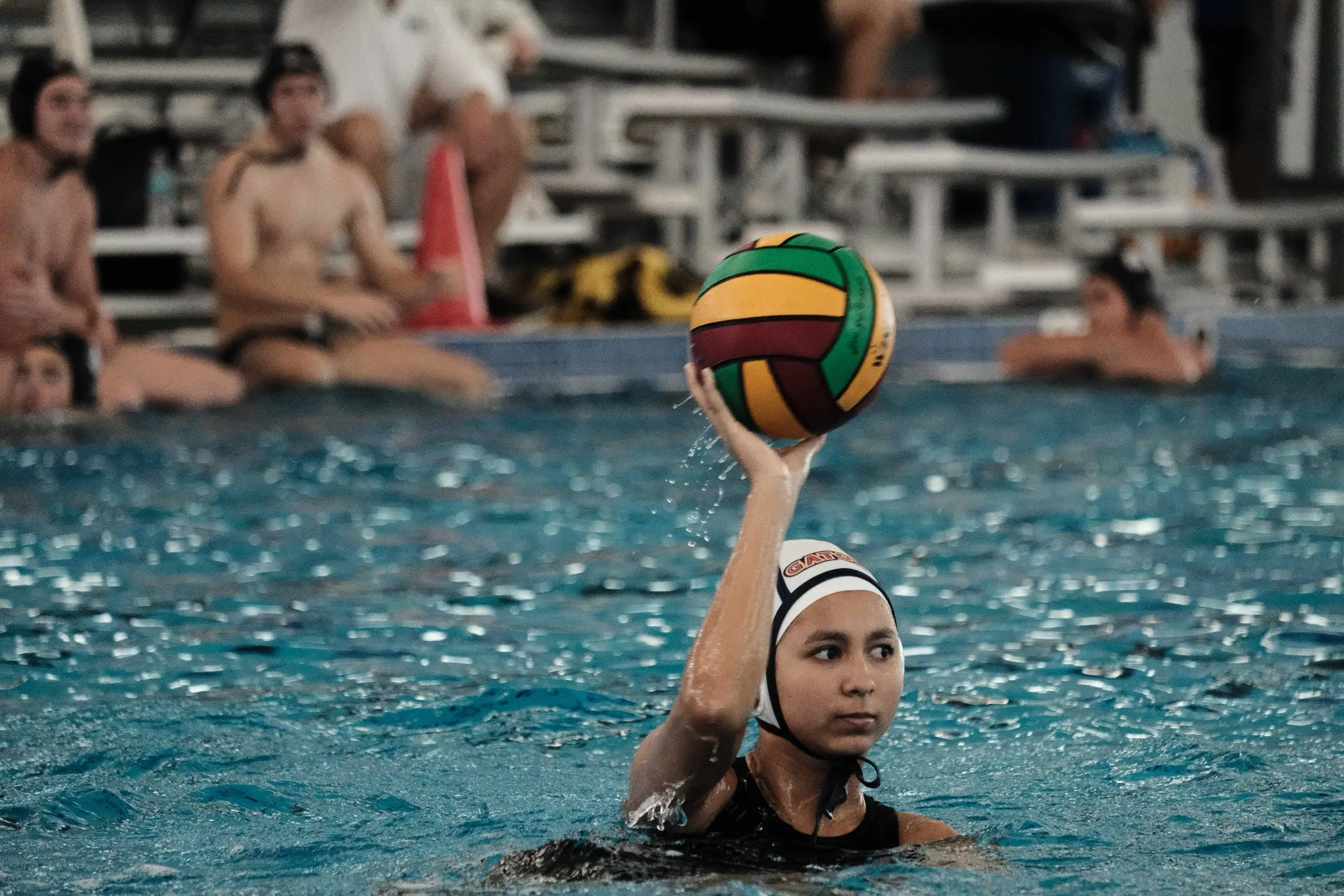An athlete holding the ball high, looking for the pass