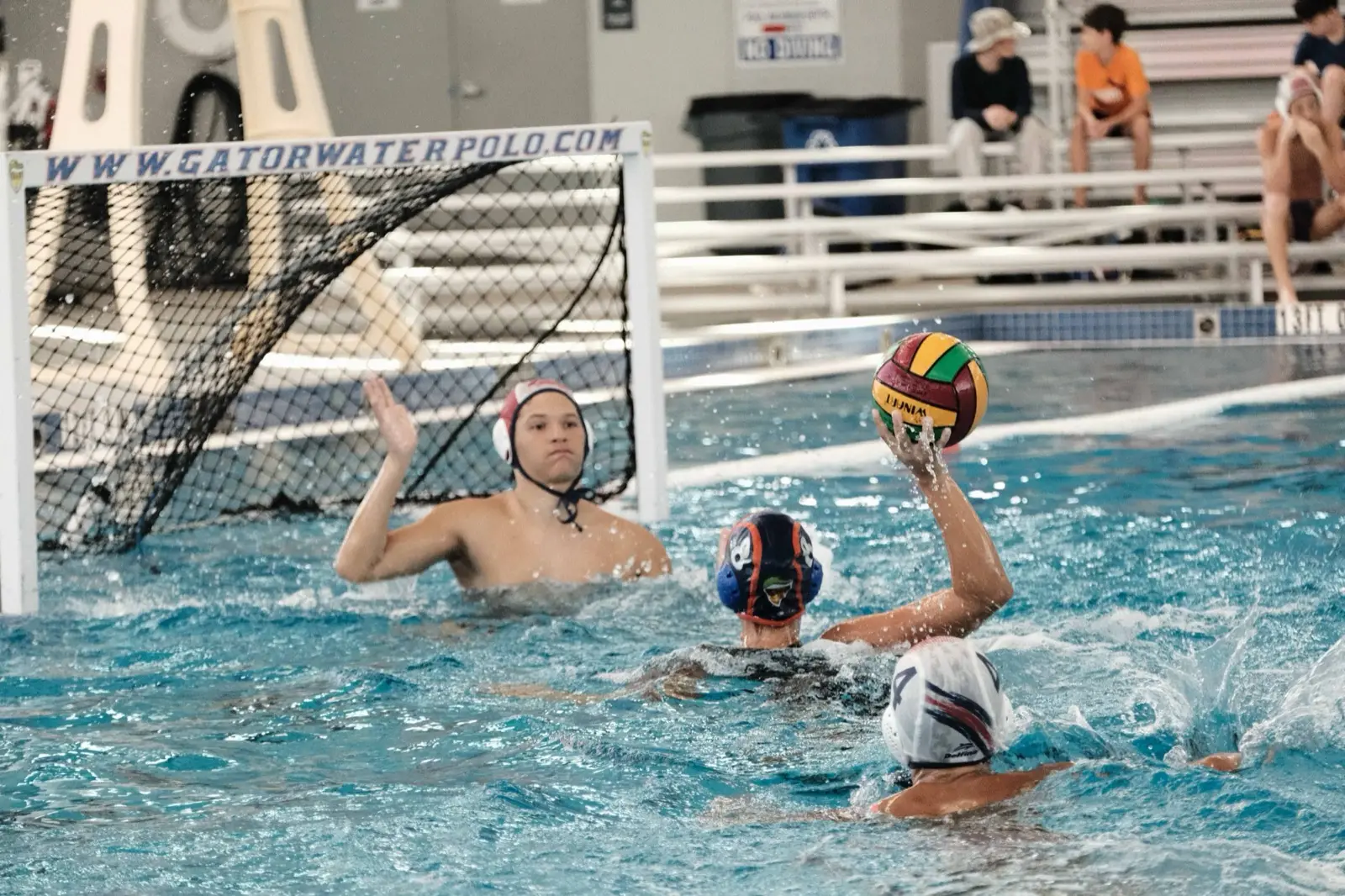 A goalkeeper and shooter face off at the Gator Water Polo cage