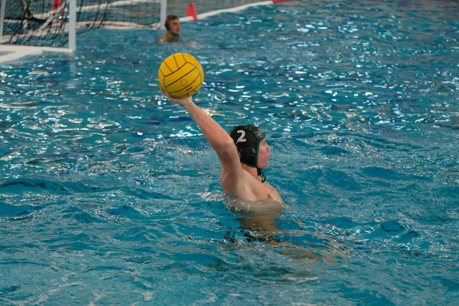 A player in a black cap lifting the ball to shoot