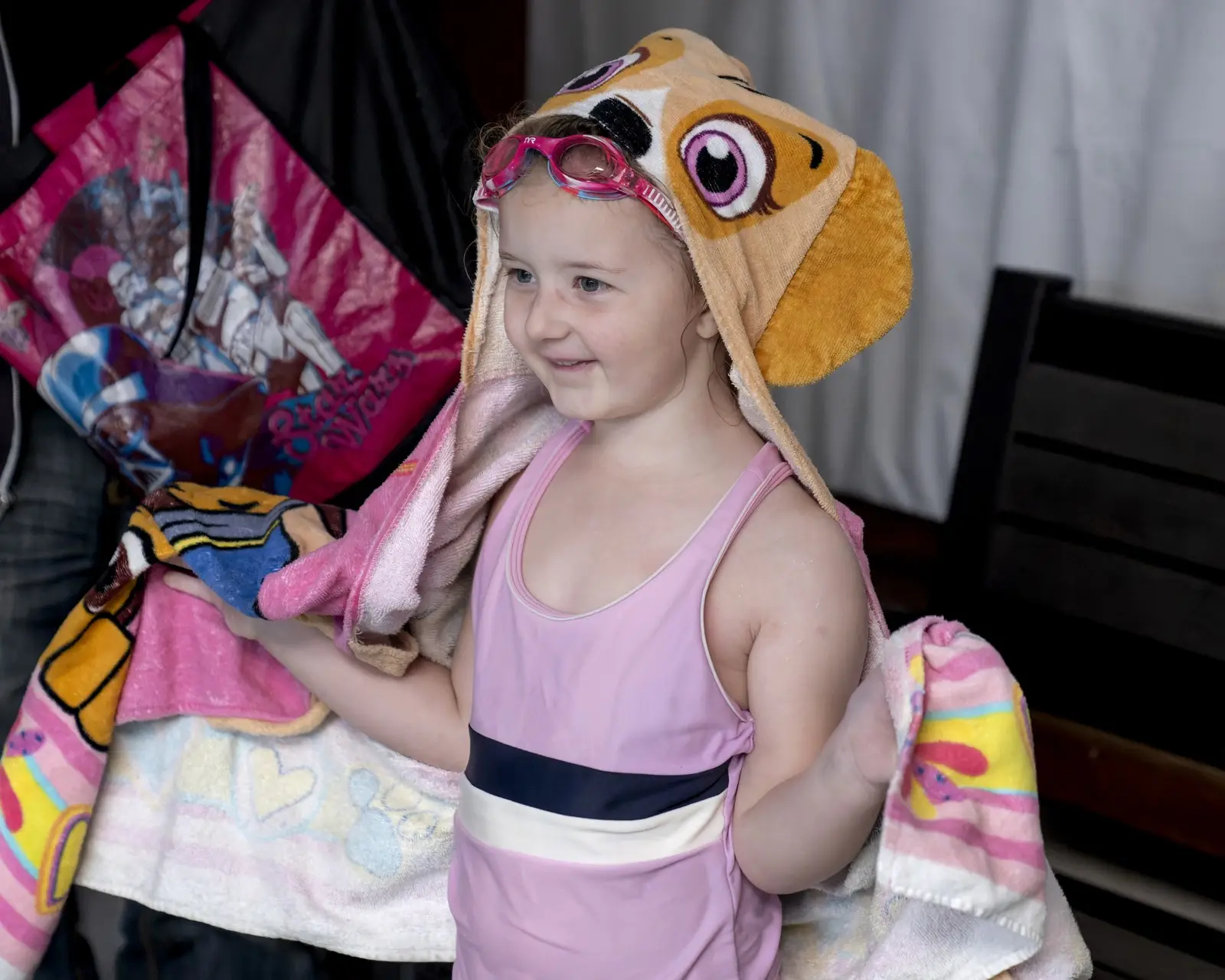 A young swimmer wrapped in a hooded towel after her lesson