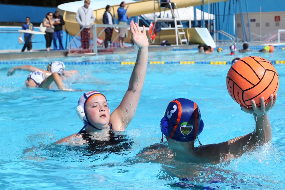 An early Gator Water Polo athlete winding up to shoot at NE Pool
