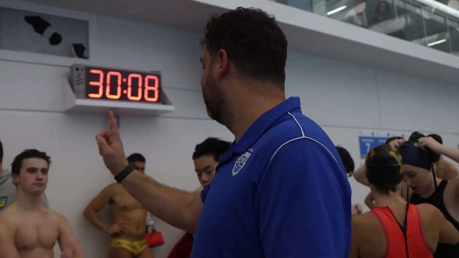 A coach teaching athletes beside the shot clock at the Surrey clinic