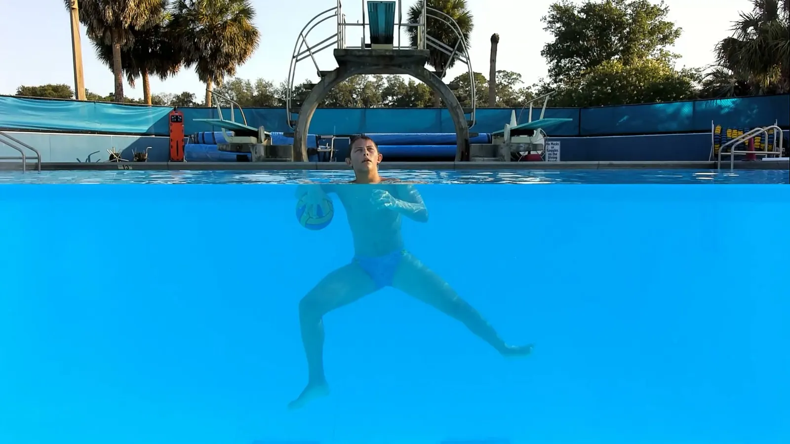 An athlete holding the ball in an eggbeater stance, filmed underwater at the 2026 summer event